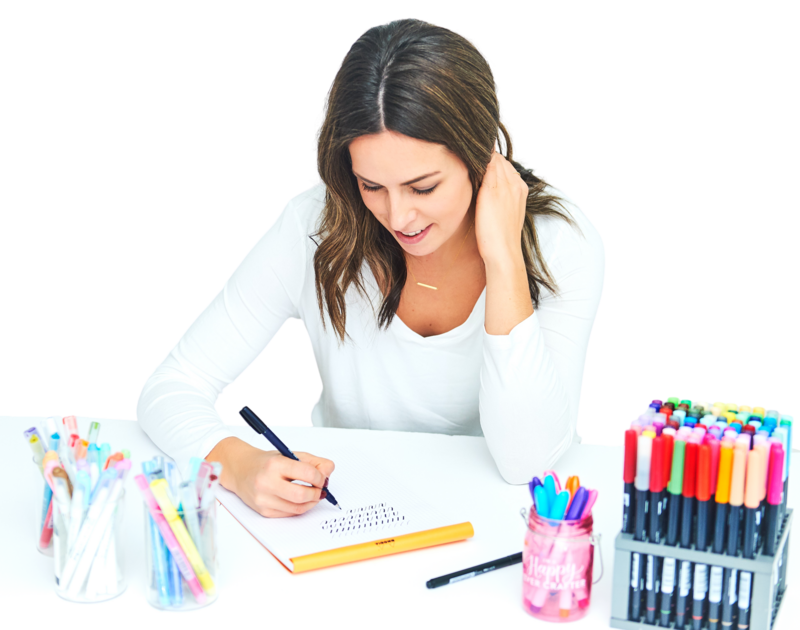 Becca at her desk with her full pen collection